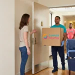 A Summer Moving crew delivers a branded box and an armchair through an apartment doorway as a resident greets them.